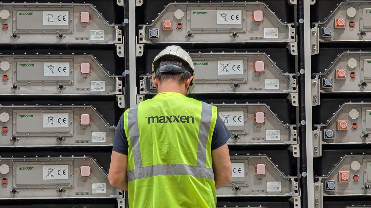 A Maxxen worker in front of the battery racks of an energy storage system